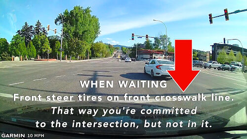 Wait to make your turn with the front steer tires on the front crosswalk line. That way you're committed to the intersection, but not in the intersection.